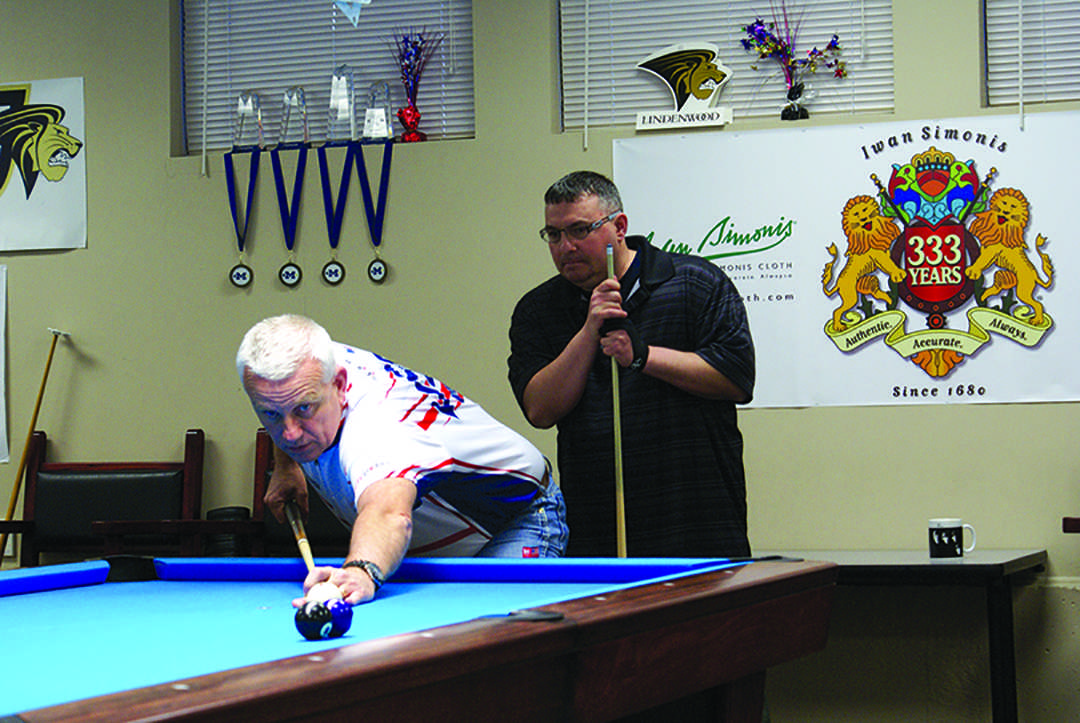 Photo by Phil Brahm Rob Geer looks on as billiards head coach Mark Wilson leads a lesson on technique at the Lindenwood Billiards Arena during Geer’s visit to Lindenwood. 