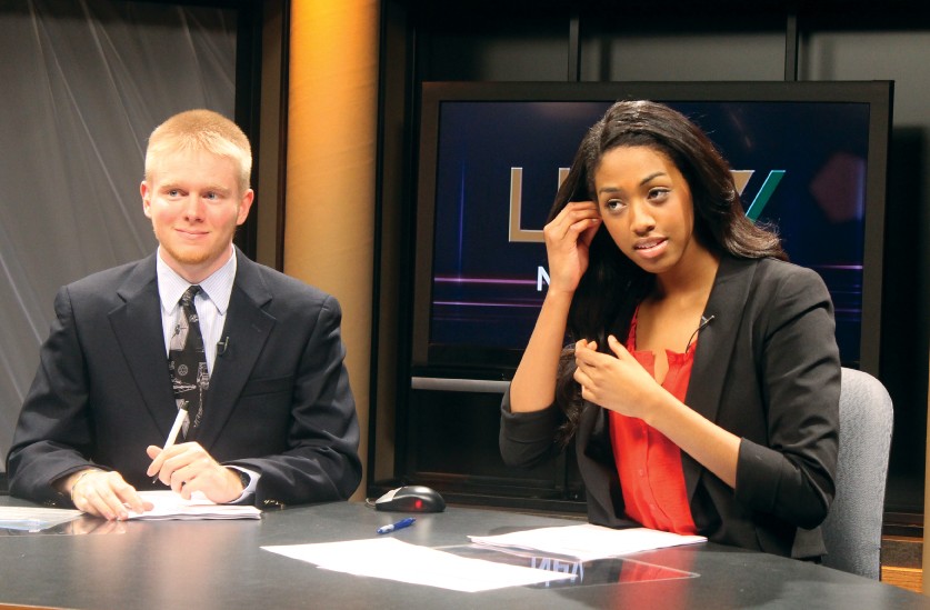 LUTV+news+anchors+Steve+Kornfeld+and+Paige+Hill+take+their+places+at+the+news+desk+on+set+in+the+studio+as+they+prepare+for+the+broadcast.+Kornfeld+and+Hill+are+just+two+of+the+many+students+involved+in+filming+Lindenwood%E2%80%99s+newscast.+Legacy+photo+by+Kelsey+Rogers