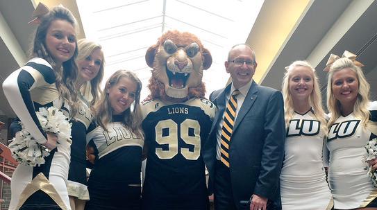 Photo from Day Admissions
President Michael Shonrock gets to know Leo the Lion and members of the Lindenwood cheer team.