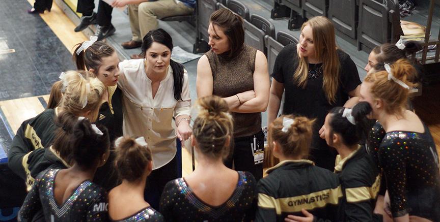 Head coach Jen Kesler speaks to her team after they completed their first rotation of the semifinals. <br> Photo by Phil Brahm