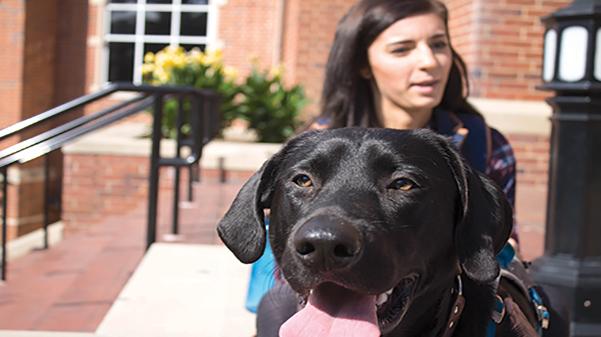 Alayne Beshey and her service dog Iink outside of the Spellmann Center.  Photo by Mili Mena
