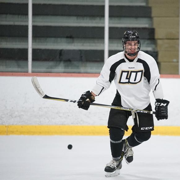 Austin Wilk smiles and skates with the puck on practice at the Wentzville Ice Arena on Sept. 30. Wilk is the assist leader for the team, with five assists according to Lindenwood Athletics. 
Photo by Mitchell Kraus. 