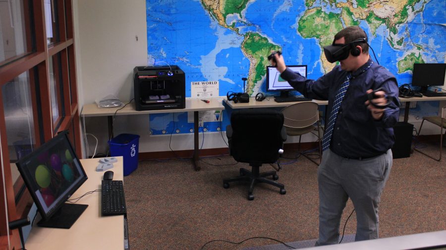 Adjunct professor Chris Pusczak tests the new equipment in the test virtual-reality studio in Spellmann 4085.  Photo by Lindsey Fiala. 