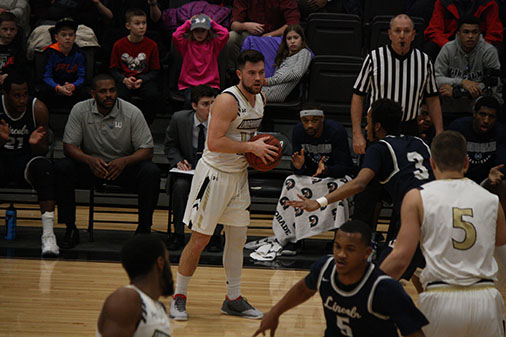 Junior Adam Pohlman looks past a Lincoln defender for a teammate to pass the ball to during the Feb. 10 game against Lincoln University of Missouri. <br> Photo by Matt Hampton