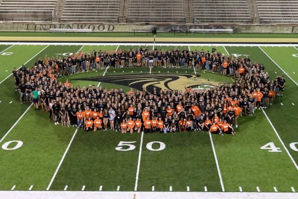 In black shirts, freshmen pose for a class photos with their Lion Leaders, wearing orange shirts, sprinkled in the crowd at Playfair on Thursday night. <br> Photo used with permission from Angie Royal.