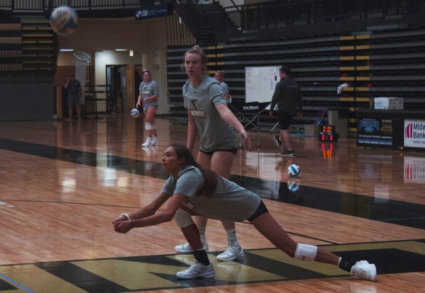 Freshman Mackenzi Sifuentes bumps the ball up in a drill while Sophomore Sadie Kosciuk waits for her turn during practice.  Photo by Lindsey Fiala