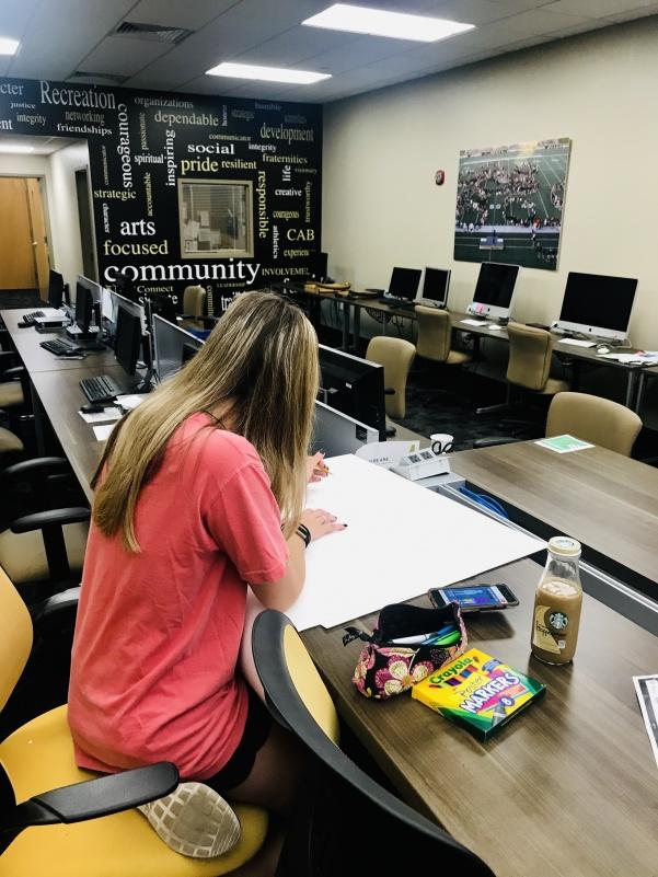 Co-Executive Event Coordinator, Tara LeClere begins to work on a display posters for the last two days of Better Yourself Week inside the Student Involvement office.   Photo by Lauren Pennock.