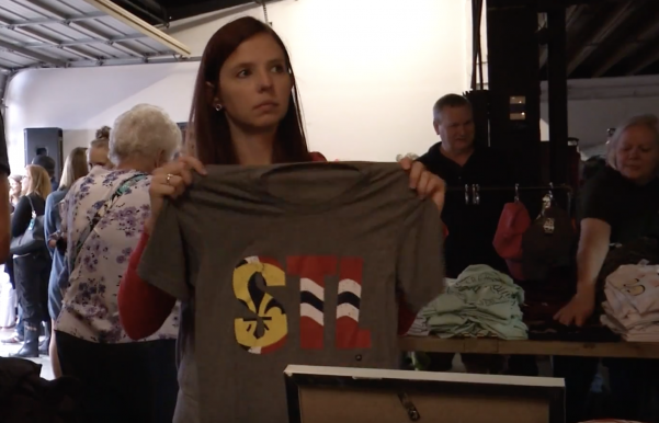 A customer shops at Arch Fest, looking at apparel that was originally intended to be sold at LouFest 2018.
 Photo by Kayla Drake