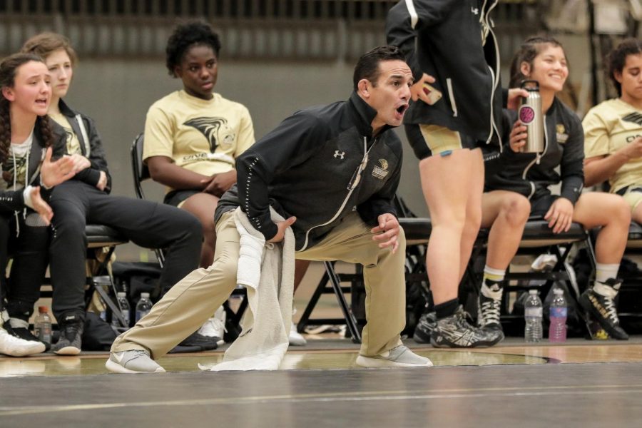 Coach Mike Mena reacts after Belle Erhardt pins down her opponent in the dual against Emmanuel College on Thursday, Dec. 5 at Hyland Arena. 