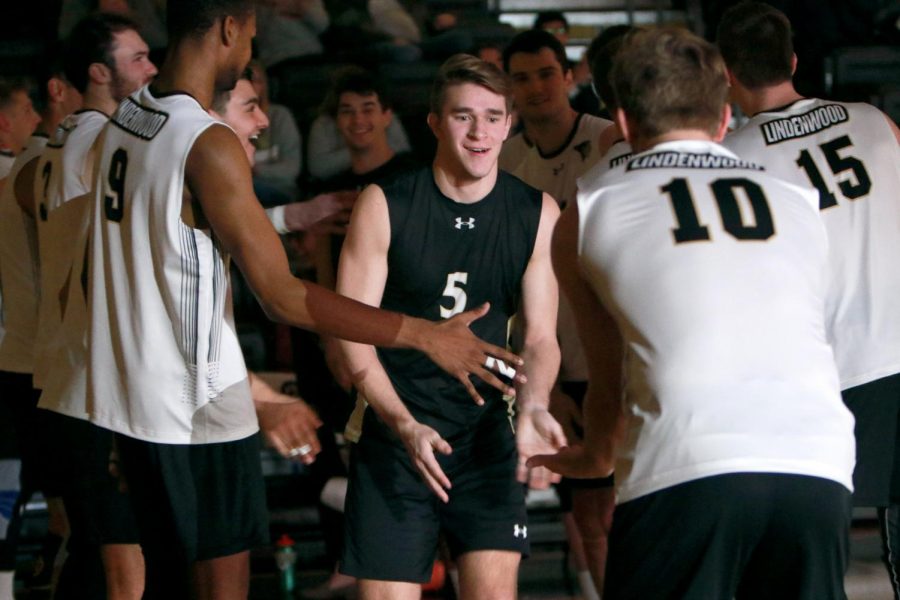 Kyle Deutschmann (#5) comes out to be embraced by teammates in a home mens volleyball game at Hyland Arena.