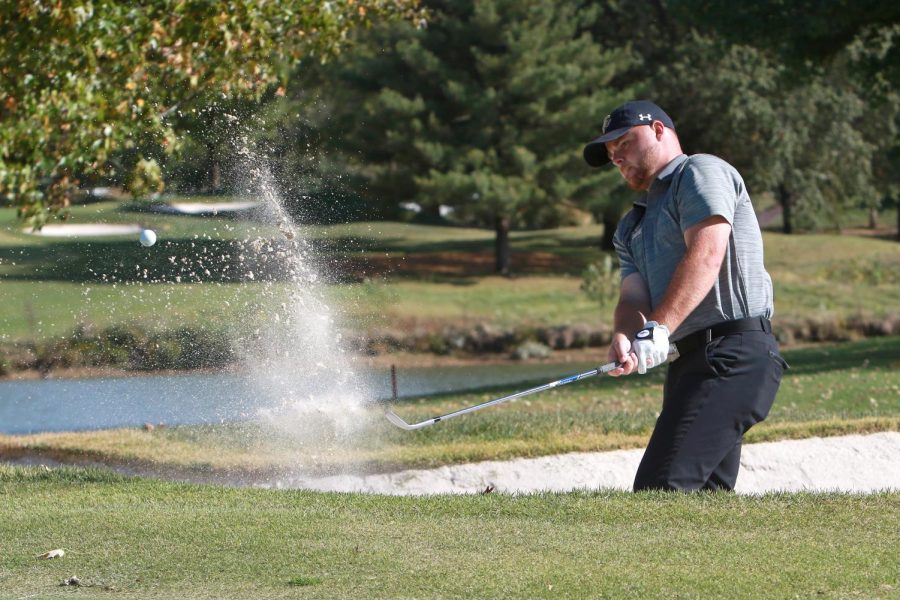 Junior Caleb Picker attempts to chip his ball out of the bunker during a tournament in the fall of 2020.