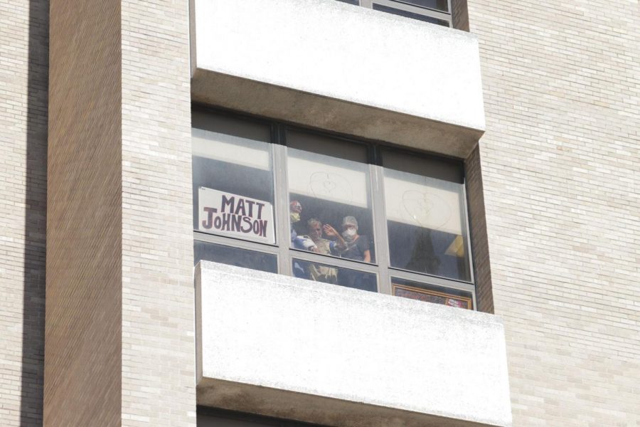 Matt Johnson waves to cars as they drive past his window in support. 