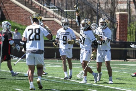 Junior attacker Adrian Thompson raises his hand in the air to celebrate after scoring a goal during the home game at Hunter Stadium against Lewis University on Saturday, April 9. Lindenwood won the game by a final score of 14-10.