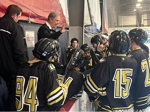 D1 Head Coach Ron Bielsten discusses game plan with his team between the first and second periods
