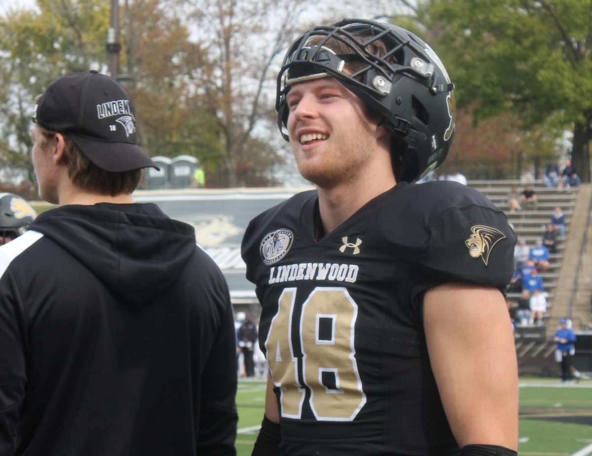 Cole Watson smiles on the sidelines after a play. 