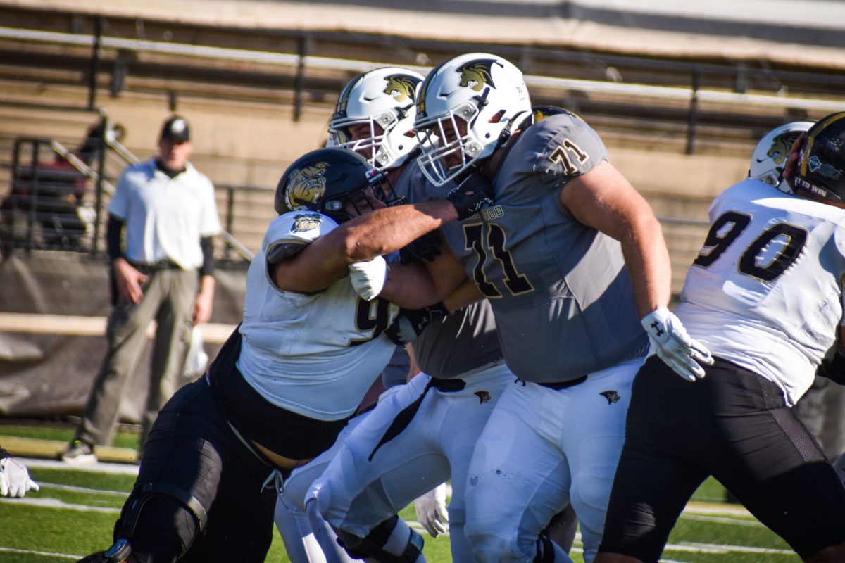Offensive lineman Jacob Swihart pushes through the line of scrimmage in a game against Bryant University. 