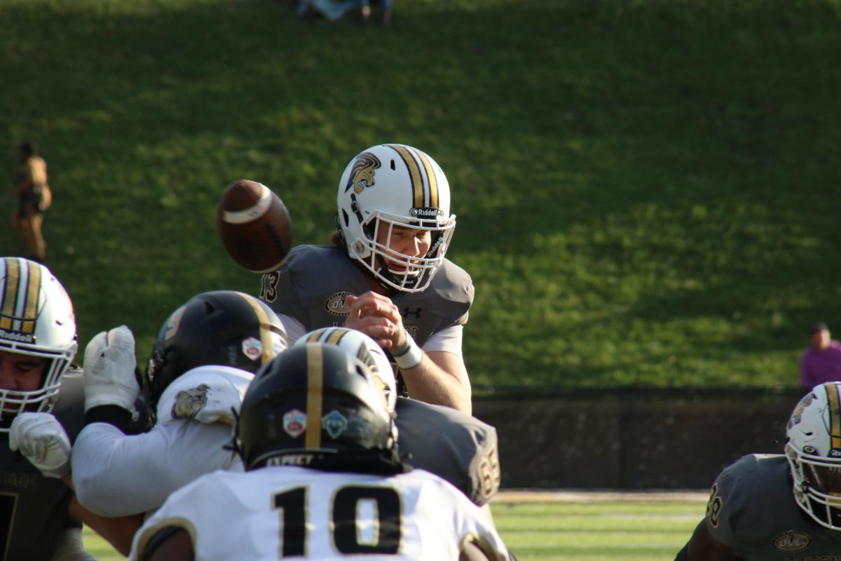 Quarterback Cooper Justice mishandles a snap in a game against Bryant University. 