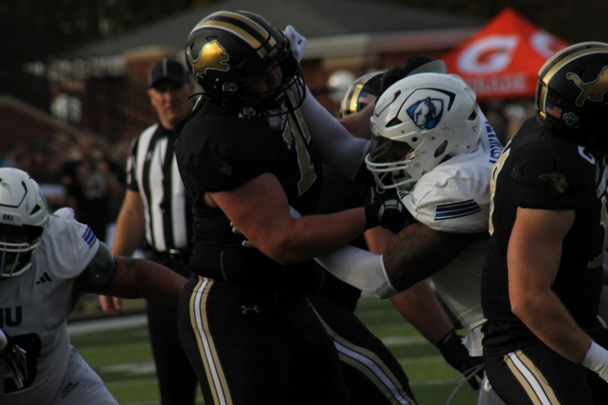 Offensive lineman Ethan Johnson blocks a Panthers defender during a play. 