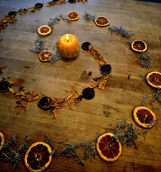 A candle light spiral made of lavender, sunflower petals, oranges, and lemons