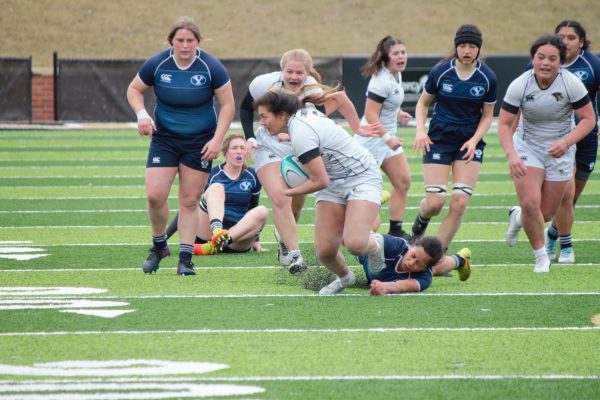 A Lindenwood rugby player breaks a tackle as she moves down the pitch with the ball. 