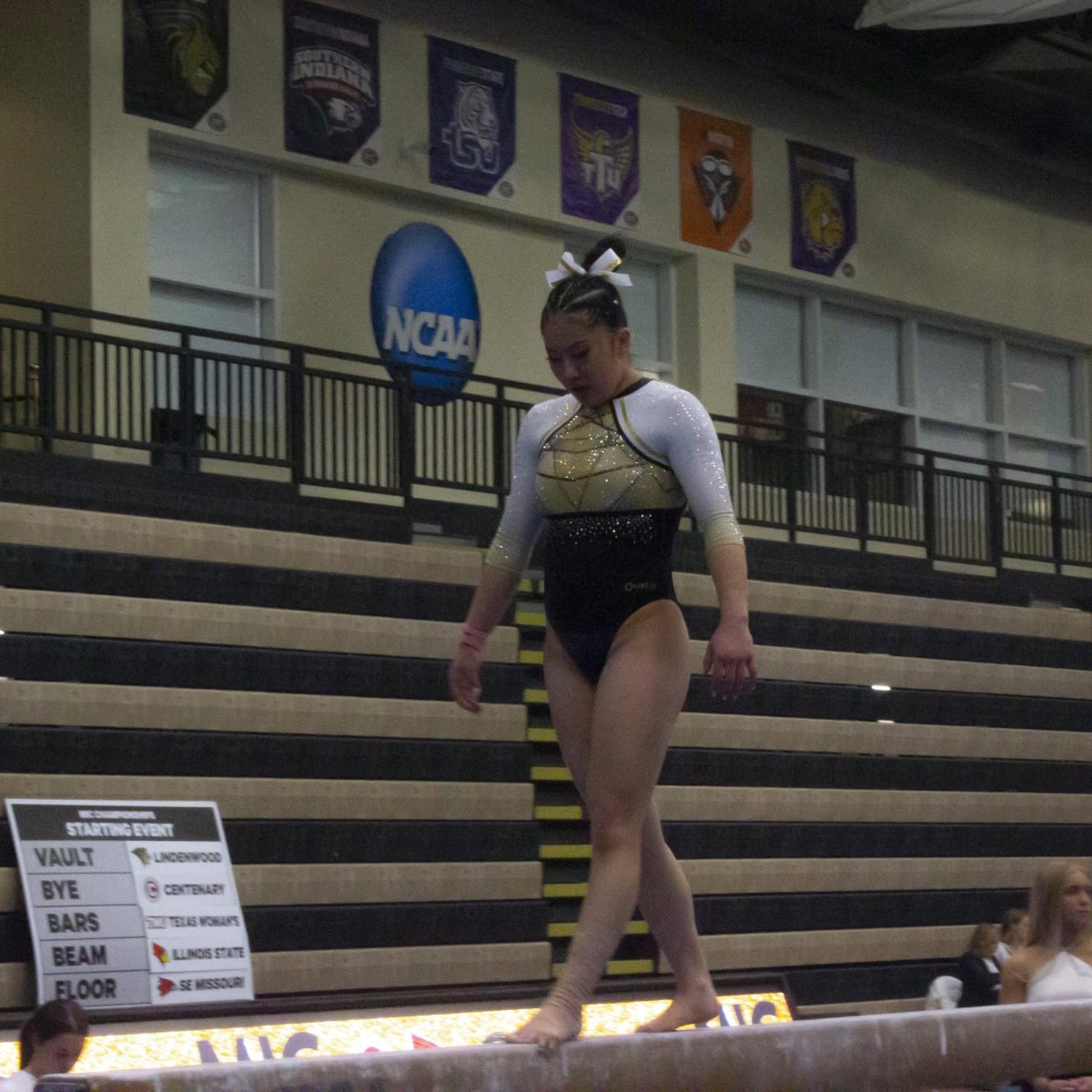 Nya Kraus competes in the beam competition in the Midwest Independent Conference championship. 