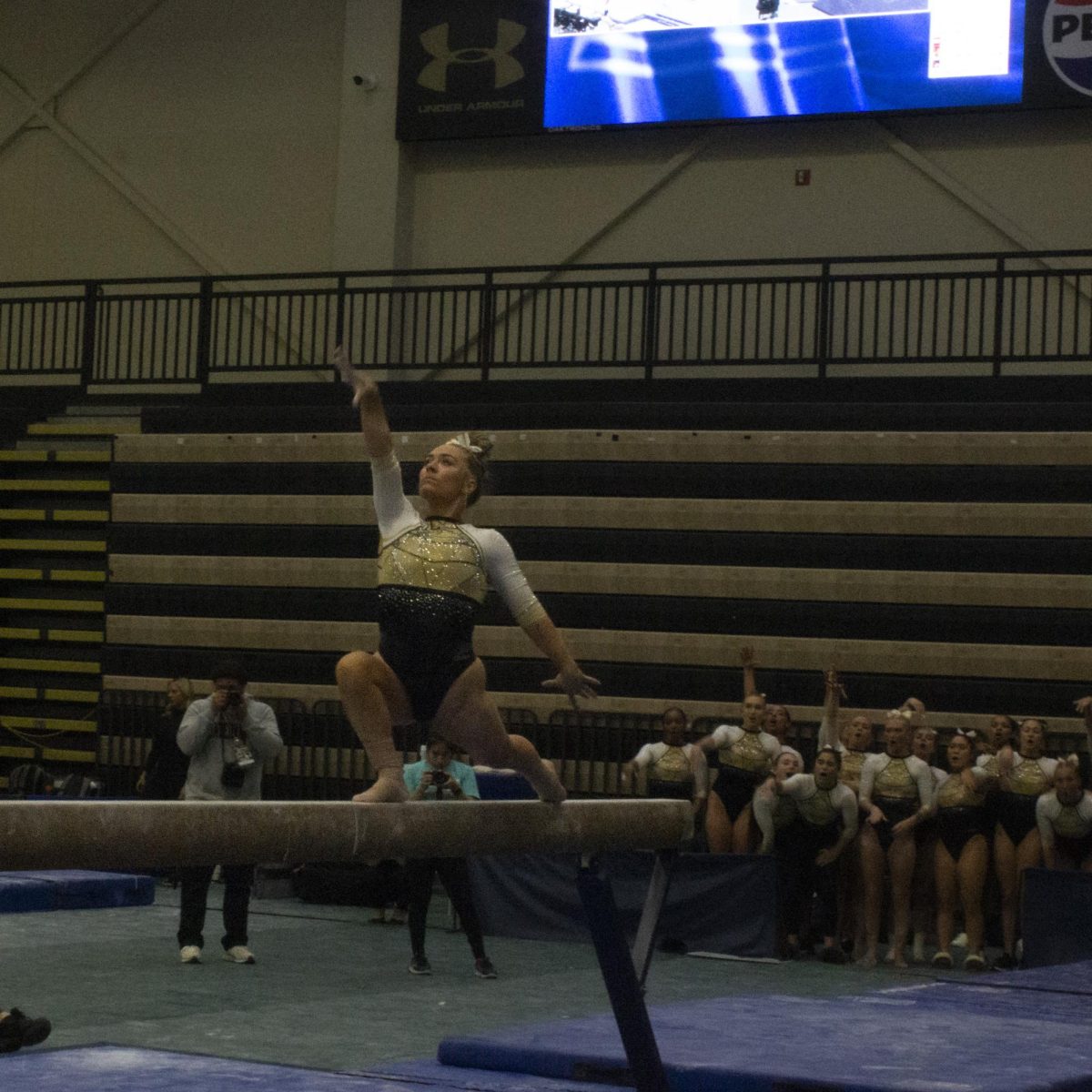 Madison Rush competes on the beam during the Midwest Independent Conference championships. 