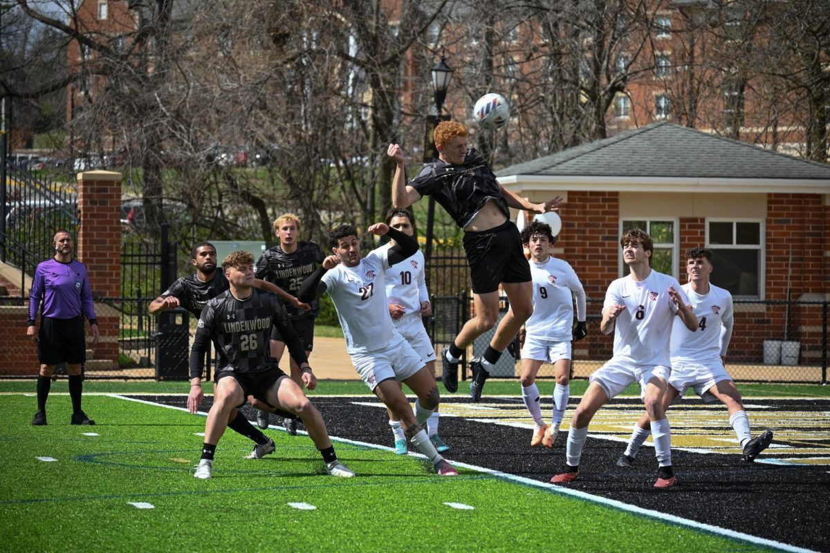 Luke Nealy jumps in the air to deflect a ball with his head against St. Charles Community College. 