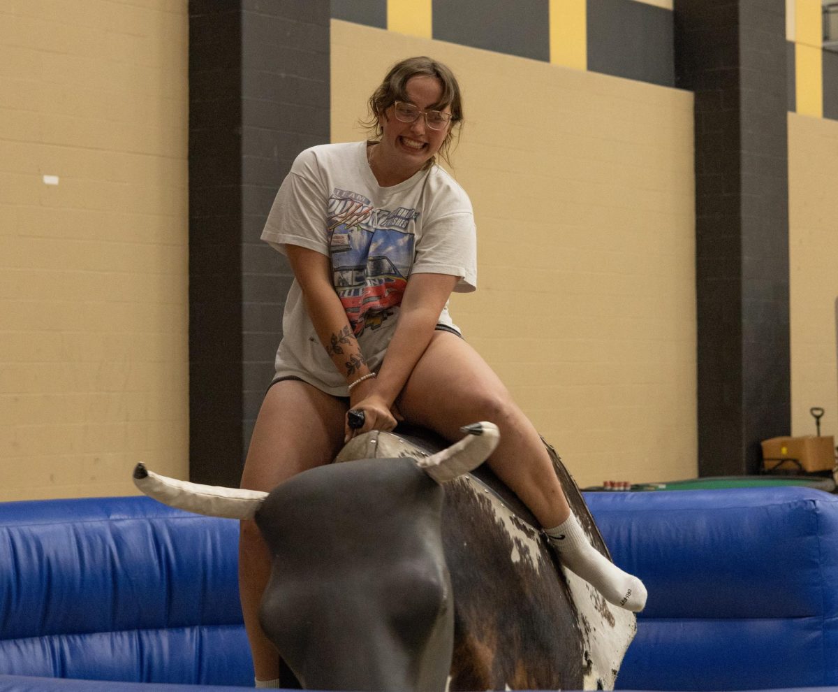 A student rides the mechanical bull at Late Night Breakfast. The event was Space Cowboy themed.