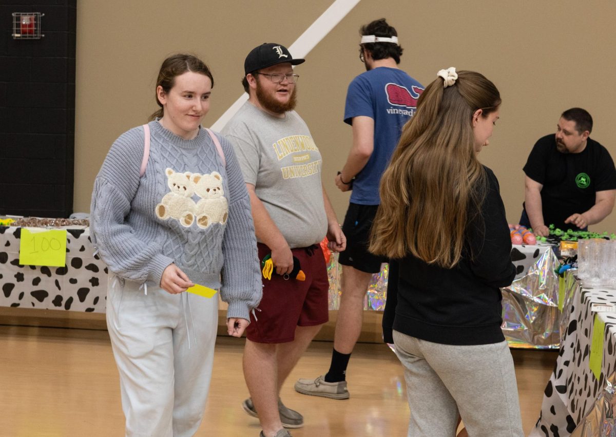 Freshman Rin Moyers preparing to pick out a prize after participating in the cash cube. Students grabbed fake money in the cube and used it to purchase prizes at the event.