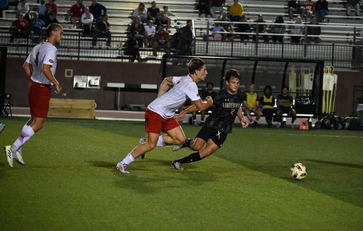 Josh Francombe attempts to outrun a SIUE defender, pursuing the ball. 