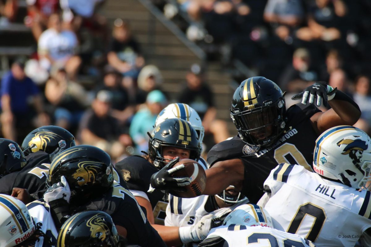 Running back Cortezz Jones leaps and reaches over a group of Charleston Southern players in attempt to score a touchdown. 