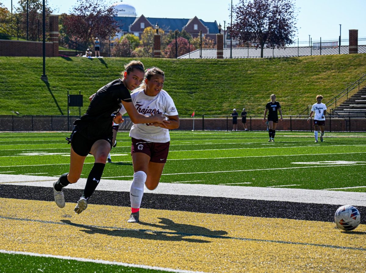 Lily Sutter makes contact with a Trojans player while pursuing the ball. 