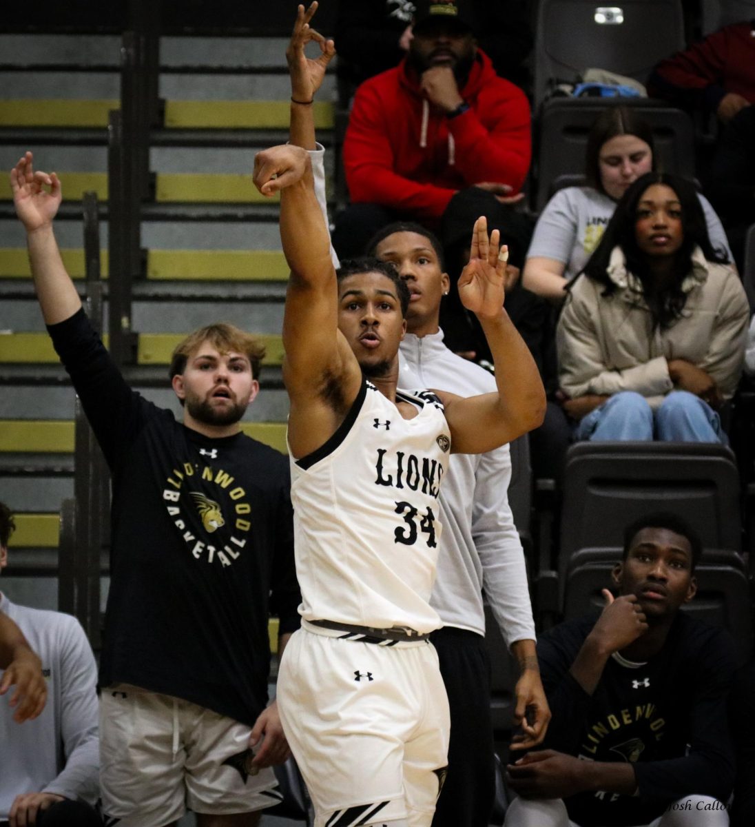 Clayton Jackson attempts a three-point shot as teammates Grant Redd, Anias Futrell, and Aly Tounkara look on. 