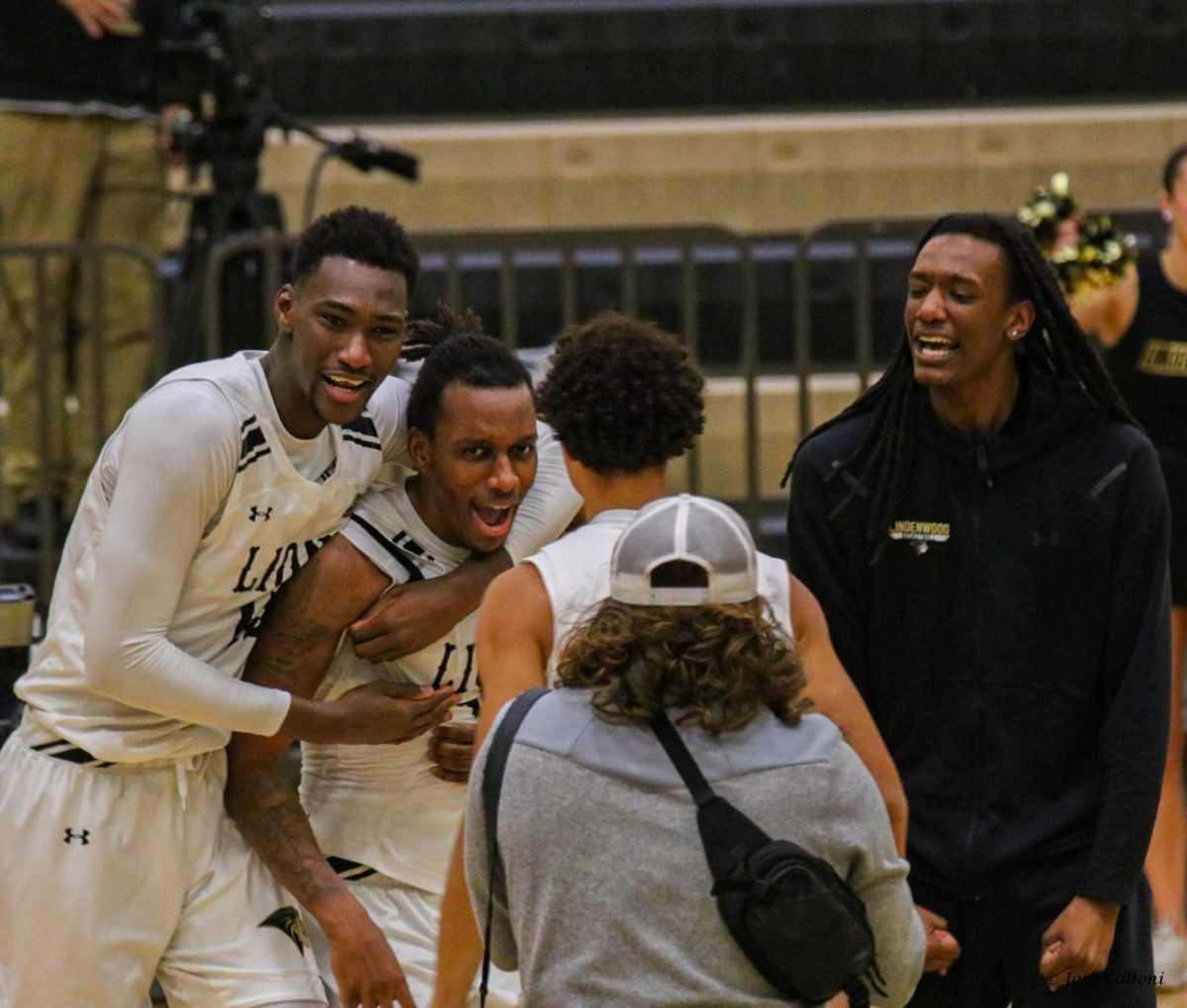 Jordan Wildy, Aly Tounkara and Colin Ruffin embrace Nathan Johnson Jr after he scores a game-winning three-pointer against UT Martin. 