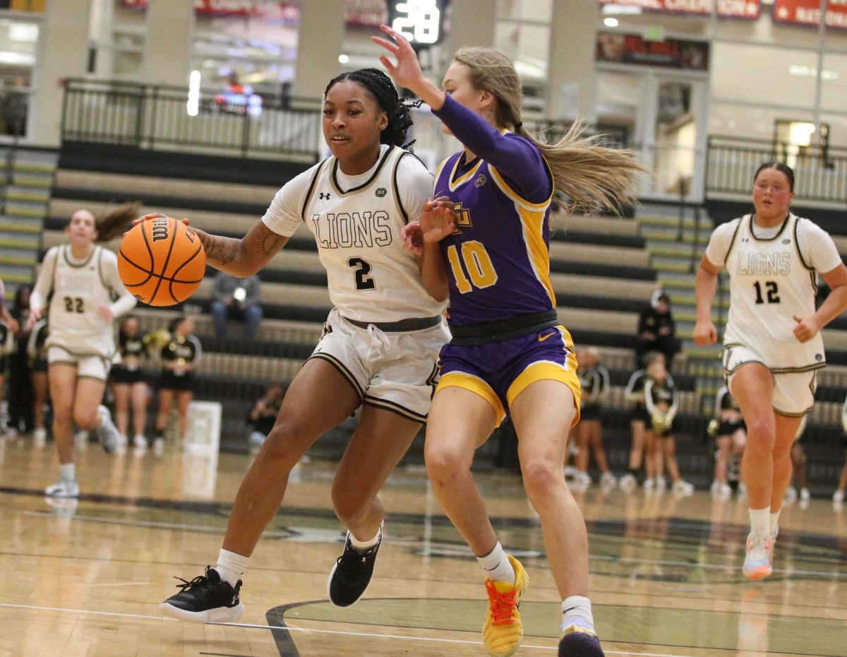 Aleshia Jones dribbles the ball with her right hand while being guarded by a Golden Eagle player.